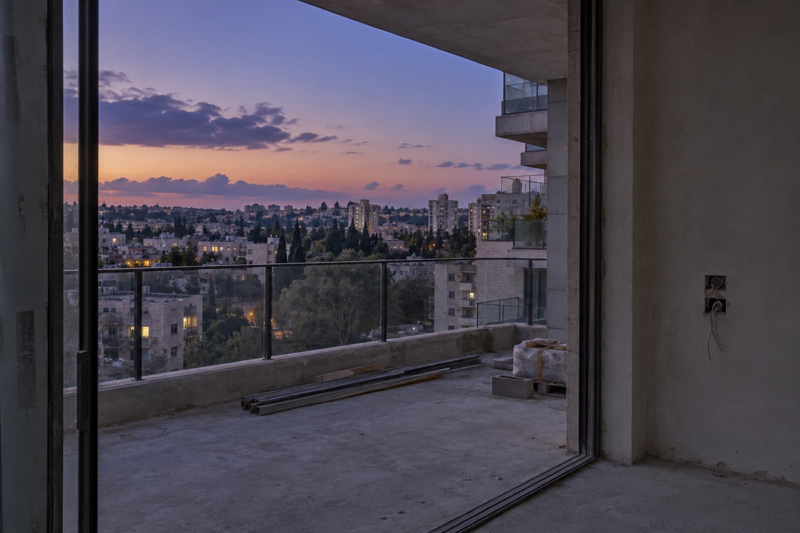 מרפסת דירה בקומה גבוהה עם מעקה זכוכית